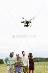 Family playing with drone in field