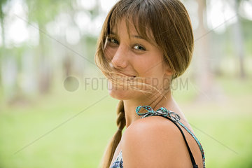 Young woman smiling over shoulder  portrait