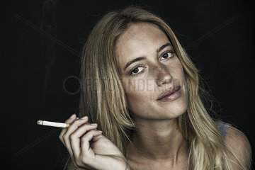 Young woman holding cigarette  portrait