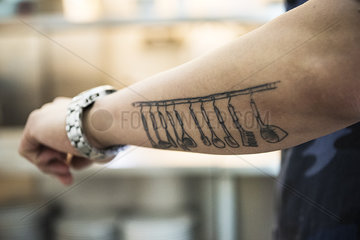 Kitchen utensils tattooed on arm