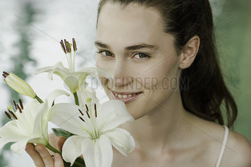 Young woman smelling lilies