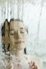 Woman bathing in artificial waterfall