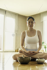 Woman sitting on floor meditating