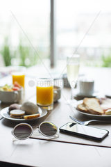 Sunglasses and smartphone on breakfast table in cafe