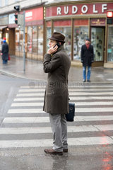 Wien  Oesterreich  Mann mit Hut  Telefon und Aktentasche