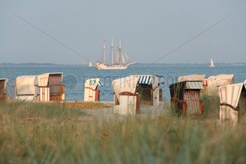 Strande  Deutschland  Strandkoerbe am Ostseestrand  auf der See eine Dreimast-Bark