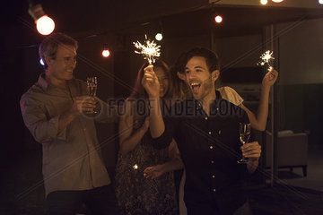 Friends celebrating with champagne and sparklers