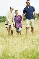 Family with one child on walk together in open field