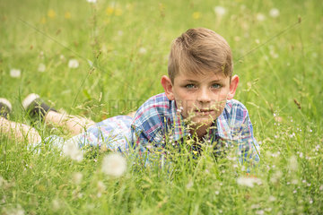 Boy lying on stomach in grass  portrait