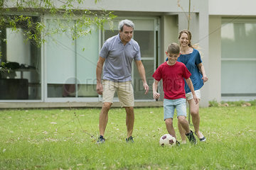 Family playing soccer together
