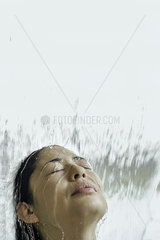 Woman standing beneath flowing water