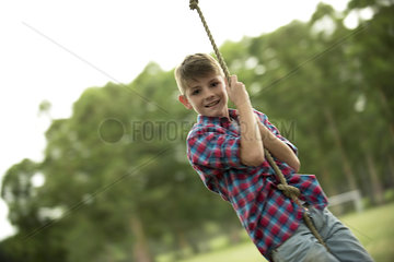 Boy swinging on rope