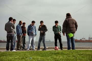 Istanbul  Tuerkei  junge Maenner sonntags auf der Promenade am Marmarameer