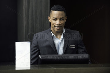 Man standing behind bank teller counter  portrait