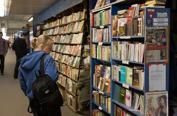 Krakau  Polen  eine junge Frau vor einem Buecherregal in einem Buchladen