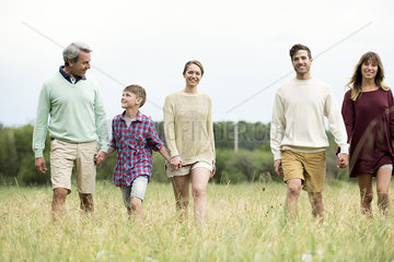 Family walking together through field of tall grass