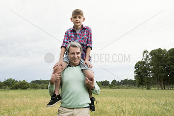 Father carrying son on shoulders outdoors