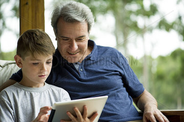 Man with child using digital tablet