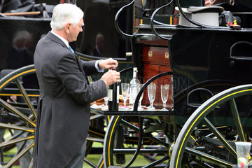Ascot  Grossbritannien  elegant gekleideter Mann schenkt an einer Kutsche Sekt ein