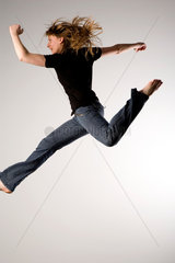 Freiburg  Deutschland  junge Frau mit Jeans bei einem Luftsprung