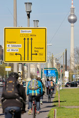 Berlin  Deutschland  Fahrradfahrer und Wegweiser auf der Karl-Marx-Allee