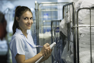 Woman checking cart of laundered bath towels