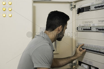 Electrician checking electric control cabinet