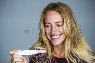 Young woman smiling pregnancy test results