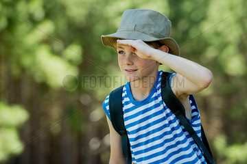 Boy shading eyes while exploring outdoors