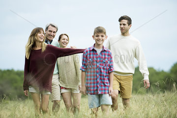 Family walking together in tall grass