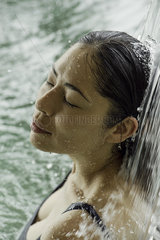 Woman standing beneath flowing water