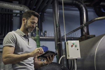 Man using digital tablet in industrial setting