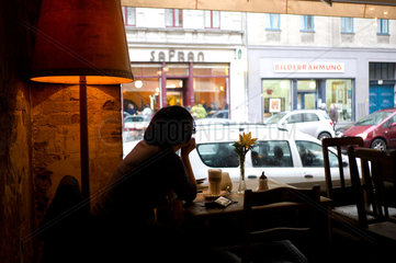 Berlin  Deutschland  eine Frau sitzt in einem Cafe und schaut aus dem Fenster