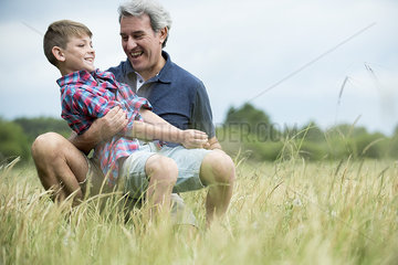 Grandfather and grandson laughing together outdoors