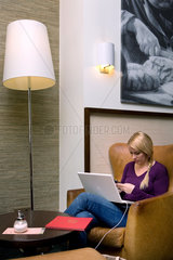 Berlin  Deutschland  eine blonde Frau mit Laptop und Mobiltelefon in einem Cafe