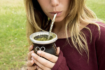 Woman drinking mate from gourd