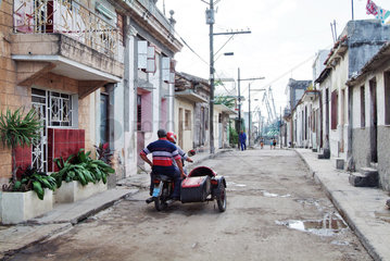 Havanna  Kuba  Motorrad mit Beiwagen faehrt auf einer Strasse