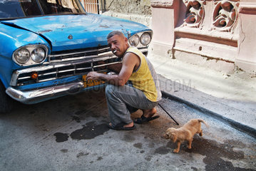 Havanna  Kuba  ein Mann bastelt an seinem Oldtimer