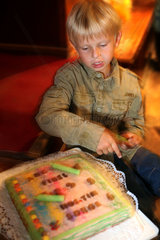 Berlin  Deutschland  Junge sitzt vor einem Kuchen