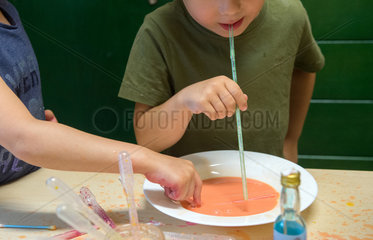 Kinder beim Spiel mit fluessigen Farben in einer Kindertagesstaette