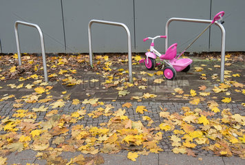 Ein angeschlossenes Dreirad fuer Kinder vor einer Kindertagesstaette