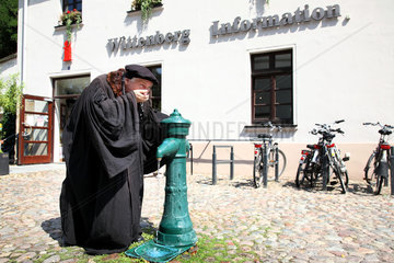 Wittenberg  Deutschland  Lutherdarsteller Bernhard Naumann erfrischt sich am Brunnen