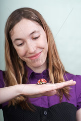 Berlin  Deutschland  junge Frau mit einem Schokoladenkaefer auf der Handflaeche