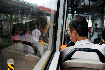 Singapur  Republik Singapur  ein Mann sitzt in einem Bus