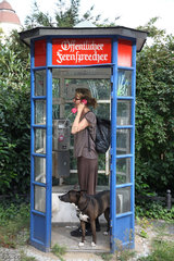 Berlin  Deutschland  eine Frau telefoniert in einer altmodischen Telefonzelle