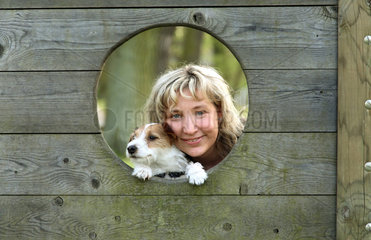 Hoppegarten  Deutschland  eine Frau und ein Hund schauen durch ein Loch