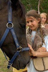 Beeskow  Deutschland  ein Maedchen im Indianerkostuem streichelt ein Pferd