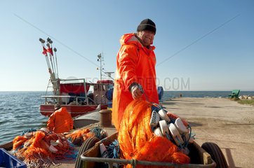 Kussfeld  Polen  kaschubischer Fischer sortiert sein Netz am Hafen