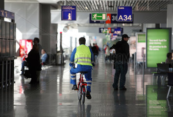 Frankfurt am Main  Deutschland  Flughafenmitarbeiter auf einem Fahrrad im Terminal
