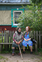Domsarycy  Weissrussland  zwei alte Frauen sitzen vor ihrem Haus auf einer Bank